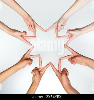 Kinder zeigen ein Zeichen der Friedenshandschrift und stehen im Kreis vor grauem Hintergrund. Zugeschnittenes Foto von Kinderhänden. Stockfoto