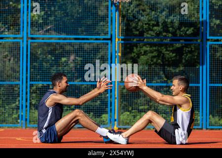 Freunde spielen Basketball afroamerikanische und kaukasische Spieler Stockfoto