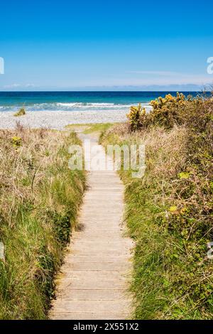 Holzsteg zum Kieselstrand in der Red Wharf Bay bei Llanddona, Isle of Anglesey, Nordwales, Großbritannien Stockfoto