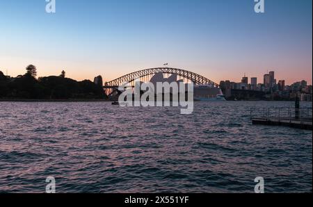 Die Sydney Harbour Bridge umrahmt das Sydney Opera House bei Sonnenuntergang, von Mrs. Macquarie's Point aus gesehen Stockfoto