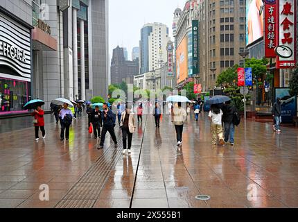 Shanghai, China - 5. Mai 2024; Regentag in der Nanjing Road, einer Fußgängerzone, die sich vom Bund bis zum People's Park erstreckt. Stockfoto