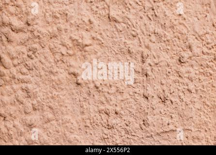 Abstraktion. Die Textur der zementverputzten und bemalten Wand in hellrosa Nahaufnahme Stockfoto