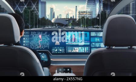 Futuristisches Konzept: Eleganter Geschäftsmann, der die Navigations-App auf einem Augmented Reality Dashboard mit Finanznachrichten nutzt, während er in einem autonomen, selbstfahrenden emissionsfreien Elektroauto sitzt. Stockfoto
