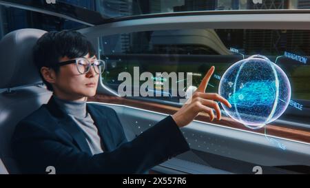 Futuristisches Konzept: Eleganter Geschäftsmann, der den Standort in einer interaktiven 3D-Navigations-App auf einem Augmented Reality Dashboard festlegt, während er in einem autonomen, emissionsfreien Elektroauto sitzt. Stockfoto