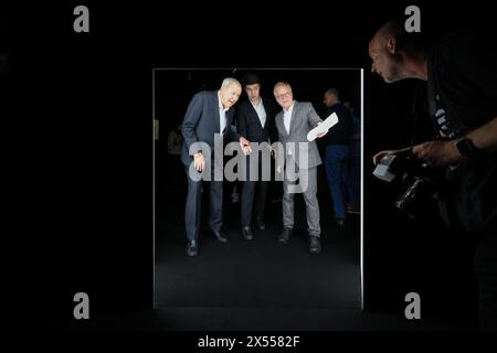 07. Mai 2024, Sachsen, Leipzig: Robert Wilson (l-r), US-amerikanischer Regisseur und Künstler, seine Assistentin Liam Krumstroh und Olaf Thormann, Direktor des Grassi Museums für Angewandte Kunst, gehen durch eine sehr niedrige Eröffnung in der Ausstellung „A Chair and You“ im Grassi Museum für Angewandte Kunst. Die Show wirft einen Blick auf eine der weltweit wichtigsten privaten Stuhlsammlungen. Die rund 140 Stühle, deren skulpturaler Charakter weit über die übliche Typologie der Stühle hinausgeht, wurden vom Genfer Unternehmer und Sammler Barbier-Mueller zusammengeführt. Bis zum 6. Oktober können die Besucher die Werke von More besichtigen Stockfoto