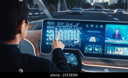Futuristisches Konzept: Stilvoller Geschäftsmann, der den Standort in einer interaktiven Navigations-App auf einem Augmented Reality Dashboard festlegt, während er in einem autonomen, emissionsfreien Elektroauto sitzt. Stockfoto