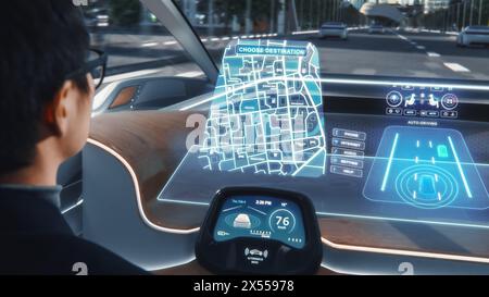 Futuristisches Konzept: Stilvoller Geschäftsmann, der den Standort in einer interaktiven Navigations-App auf einem Augmented Reality Dashboard festlegt, während er in einem autonomen, emissionsfreien Elektroauto sitzt. Stockfoto