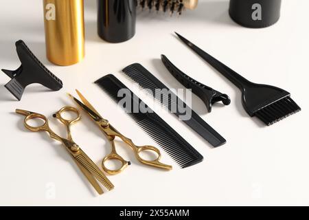 Friseurwerkzeuge. Verschiedene Scheren und Kämme auf weißem Tisch Stockfoto