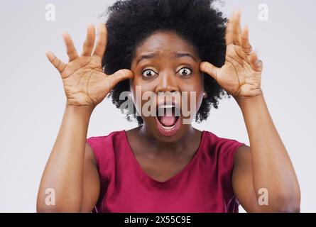 Schwarze Frau, verrückt und Porträt mit lustigem Gesicht im Studio für Comic, Comedy und alberne Emoji von weißem Hintergrund. Weibliche Person, Goofy und Hände für Stockfoto