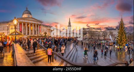 London, Großbritannien – 25. November 2023: Dämmerung am Trafalgar Square mit goldenen Sonnenuntergangstönen, die sich auf nassen Straßen reflektieren und Londons pulsierende Abendkka einfangen Stockfoto