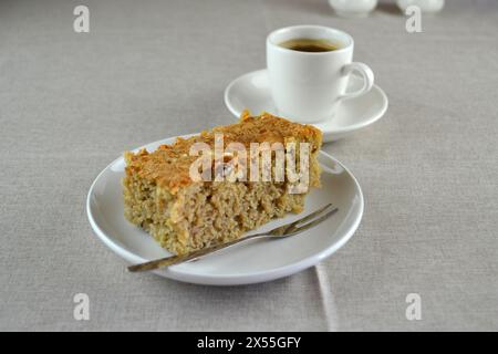 Ein köstlicher, frischer Karottenkuchen mit einer Espresso-Kaffeetasse auf einem ordentlichen Tisch. Einfache, minimalistische Komposition. Stockfoto