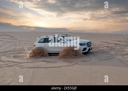 Mercedes Benz GLS 580, 4MATIC 4x4 Fahrzeuge schwelgen in der Abendsonne durch die Wüstendünen Stockfoto