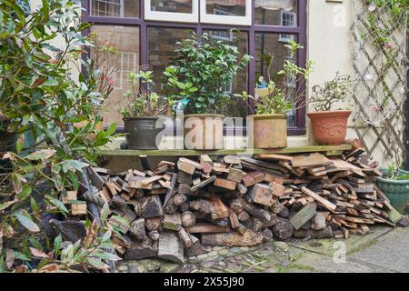 Stapel Brennholz unter einem Regal im Garten Stockfoto