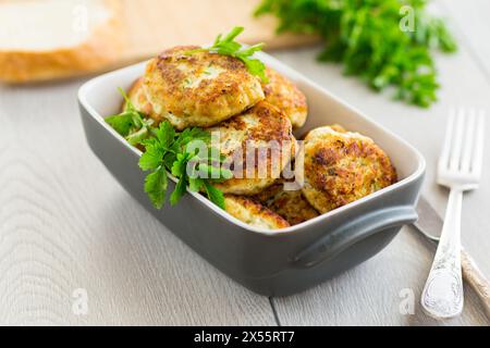 Frittierte Fleischkoteletts in keramischer Form auf einem Holztisch. Stockfoto