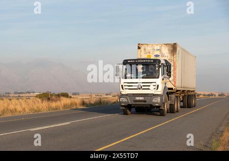 Westkap, Südafrika. 24.04. 2024. Ein Container aus Metall an Bord eines Lastwagens, der auf einem Highway in der Swartland-Region des Wes fährt Stockfoto