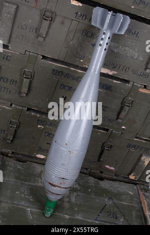 Sowjetische oder russische 120 mm Mörsergranate auf grüner Militärkiste. Text auf russisch - Art der Ammunition, Geschoss Kaliber, Geschoss Typ, Anzahl der Stücke Stockfoto