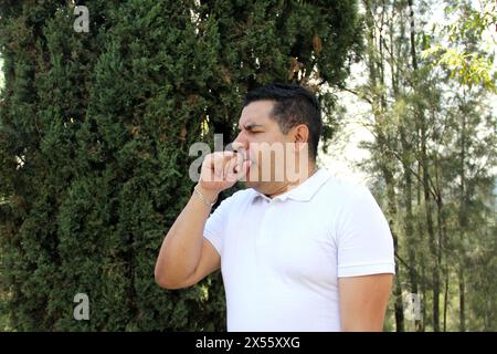 Der 40-jährige dunkelhäutige Latino-Mann leidet aufgrund der Grippe, Allergien und Umweltverschmutzung unter irritierten Augen, Nase und Rachen Stockfoto