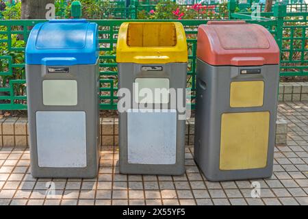 Farbcodierte Sortier- und Recyclingbehälter im City Park in Hongkong Stockfoto