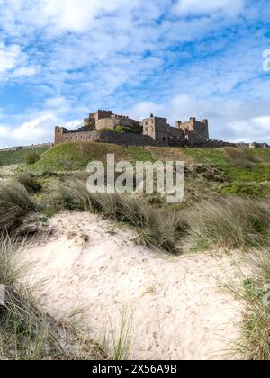 BAMBURGH CASTLE, NORTHUMBERLAND, GROSSBRITANNIEN - 23. APRIL 2024. Vertorama Landschaft Panoramablick auf Bamburgh Castle und Sanddünen auf dem wunderschönen Northumber Stockfoto