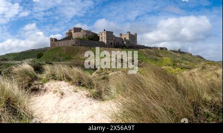 BAMBURGH CASTLE, NORTHUMBERLAND, GROSSBRITANNIEN - 23. APRIL 2024. Panoramablick auf Bamburgh Castle und Sanddünen an der wunderschönen Küste von Northumberland Stockfoto