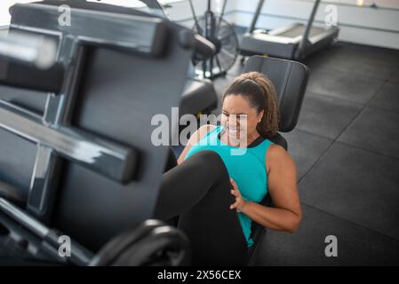 Sportliche Frau mit Multistation im Fitnessstudio. Fitness-Training im Fitnessstudio Stockfoto