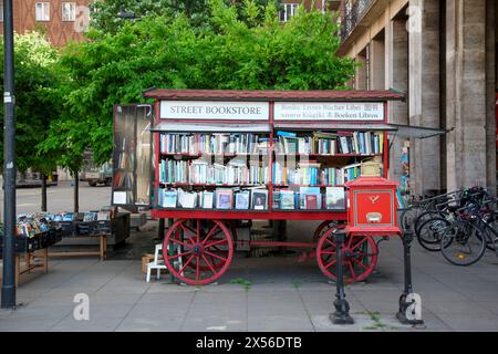 Straßenbuchhandlung auf einem alten Holzwagen, mit Büchern in mehreren Sprachen und einem Schild in Großbuchstaben in ungarischer Sprache. Stockfoto