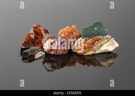 Gruppe von Steinen und Mineralien, die in einer Reihe angeordnet sind, einschließlich Vanadinit auf Barit, Aragonit Sputnik, Erythritkristalle, Mahagoni Obsidian, Rauchquarz Stockfoto