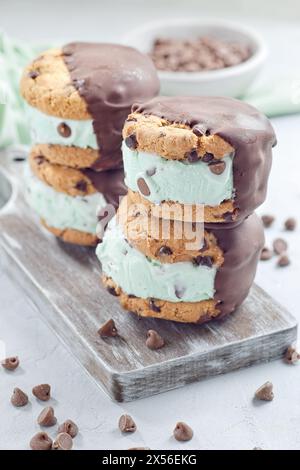 Minzschokoladenchips Eis- und Schokoladenchips Kekse Sandwiches, auf einem Holzbrett, vertikal Stockfoto