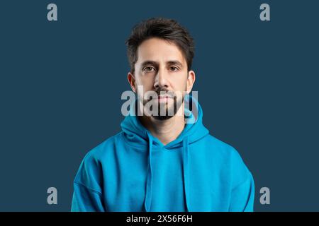 Porträt des jungen bärtigen Mannes im blauen Hoodie Stockfoto