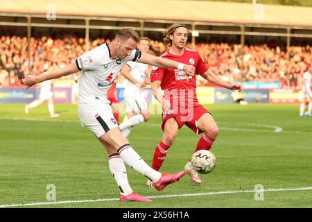 Milton Keynes Dons’ Cameron Norman im Play-off-Halbfinale der Sky Bet League Two, im Broadfield Stadium, Crawley, gegen Danilo Orsi-Dadomo in Crawley Town. Bilddatum: Dienstag, 7. Mai 2024. Stockfoto