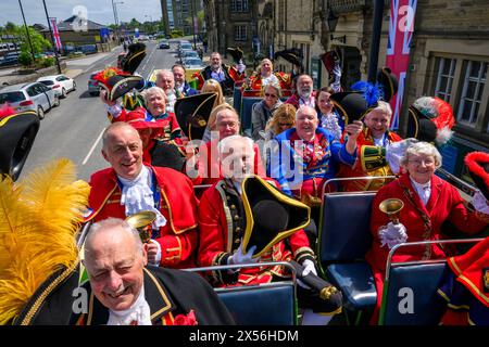 Die Stadtschreier lächeln (Pagen und Pagen in bunten Flechtuniformen) sitzen auf dem offenen Busdeck - Ilkley, West Yorkshire, England, Großbritannien. Stockfoto