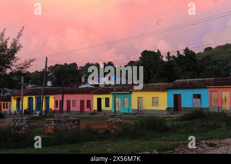 250 pastellfarbene, einstöckige Häuser in einer Reihe entlang der Amargura Street, Plaza Tres Cruces Square, unter dem rosafarbenen Himmel der Dämmerung. Trinidad-Kuba. Stockfoto