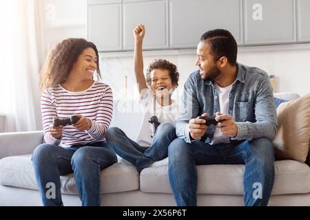 Fröhliche Familie genießt eine kompetitive Videospiel-Session Stockfoto