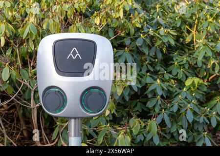 Göteborg, Schweden - 22. Januar 2022: Ladestation für Elektrofahrzeuge vor grünen Büschen. Keine Akkorde verbunden. Kein Auto oder Leute sichtbar. Stockfoto