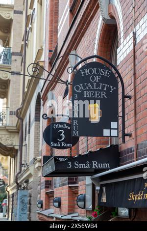 Göteborg, Schweden - 22. Januar 2022: Schwarze Schilder über dem Eingang zum Pub hängen an der roten Steinmauer. Rote und gelbe Ziegelsteine und keine sichtbaren Personen. Stockfoto