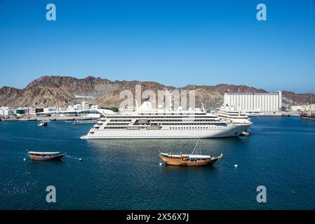 Kreuzfahrtschiff und traditionelle Dhows im Hafen von Mutrah, Muscat, Oman Stockfoto