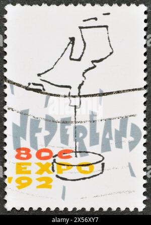 Gestempelte Briefmarke, gedruckt von den Niederlanden, die eine stilisierte Karte der Niederlande zeigt, EXPO - Sevilla, um 1992. Stockfoto