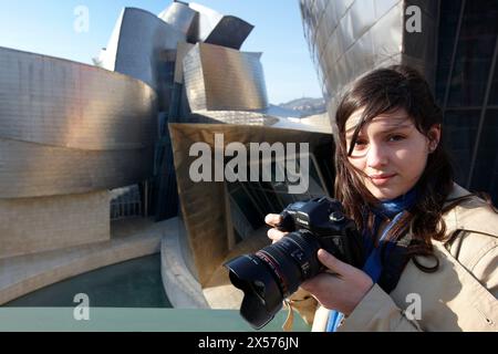 Junge Frau mit Kamera vor dem Guggenheim-Museum Bilbao. Biskaya, Baskenland, Spanien Stockfoto