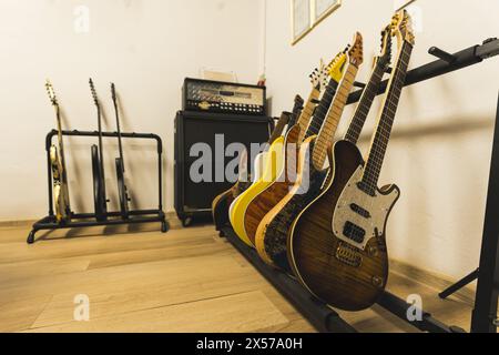 Verschiedene Farbgitarren, Verstärker und Lautsprecher im Musikstudio. Hochwertige Fotos Stockfoto