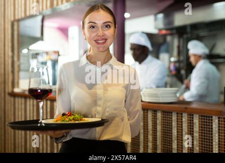 Porträt einer Kellnerin, die bereit ist, Mahlzeiten zu servieren Stockfoto
