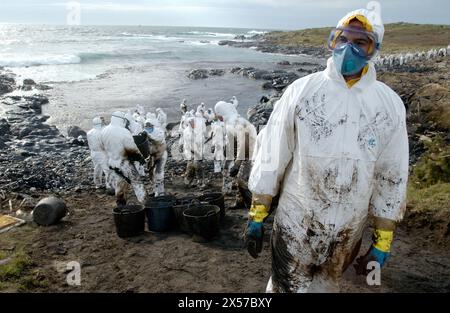 Soldaten, die mit Schutzkleidung gekleidet sind, um die Ölpest (´Chapapote´) des Prestige-Tankers zu beseitigen. Dez. 2002. Costa da Morte. Eine Provinz Coruña. Stockfoto