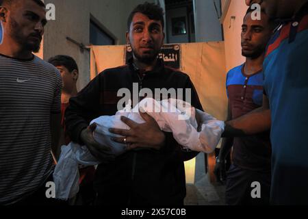 Gaza. Mai 2024. Ein Mann hält die Leiche eines Kindes fest, das bei einem israelischen Luftangriff am 7. Mai 2024 in einem Krankenhaus im südlichen Gazastreifen in Rafah getötet wurde. Die Zahl der palästinensischen Todesopfer aufgrund der laufenden israelischen Angriffe auf den Gazastreifen ist auf 34.789, wie die Gesundheitsbehörden in Gaza in einer Pressemitteilung am Dienstag mitteilten. Quelle: Rizek Abdeljawad/Xinhua/Alamy Live News Stockfoto