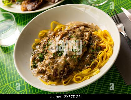 Schweinerippchen mit Pilzsauce und Linguine Pasta. Französische Küche Stockfoto