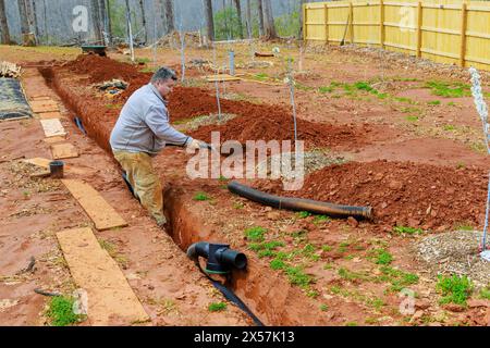 Installation eines Sturmabflussrohrs in den Grabenabfluss, um Regenwasser abzulassen Stockfoto