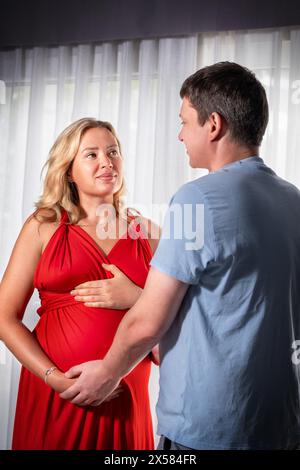 Schwangere Frau mit ihrem Mann. Mann, der den Bauch seiner Frau berührt Stockfoto