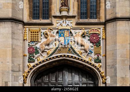 Farbenfrohe Schnitzereien eines kunstvollen Wappens über dem Tor zum Christs College mit detaillierten Skulpturen. Cambridge University, England, Großbritannien Stockfoto