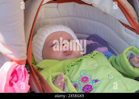 Der Junge liegt in warmen Kleidern in einem Kinderwagen Stockfoto