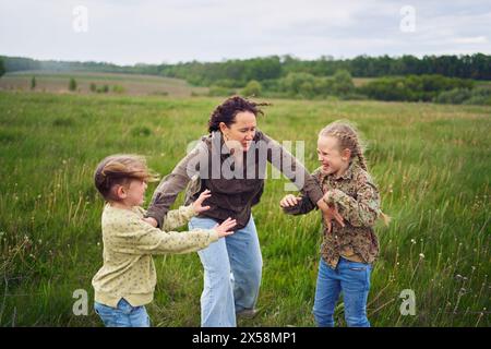 Eine Mutter zerbricht die Kinder, die im Regen auf dem Feld kämpfen Stockfoto