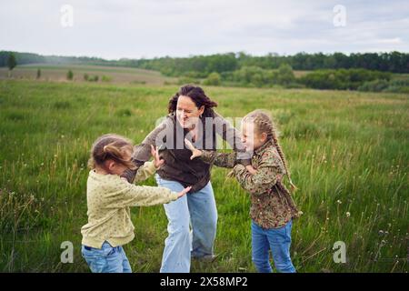 Eine Mutter zerbricht die Kinder, die im Regen auf dem Feld kämpfen Stockfoto