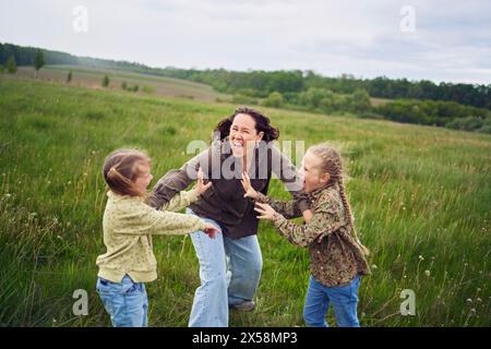 Eine Mutter zerbricht die Kinder, die im Regen auf dem Feld kämpfen Stockfoto